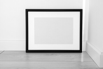 Fototapeta na wymiar Minimalist black frame mockup on white background with shadow in interior