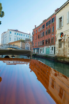Elegant Wood Motorboat 21 on Water Canal with House in a Sunny Day in Venice, Veneto in Italy. 