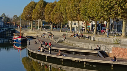 People hanging out on a quay along river Lys in Portus Ganda, Ghent