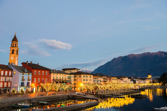 Illuminated City of Ascona and Alpine Lake Maggiore in Dusk in ticino, Switzerland.