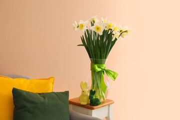 Easter decor and beautiful flowers on table near color wall
