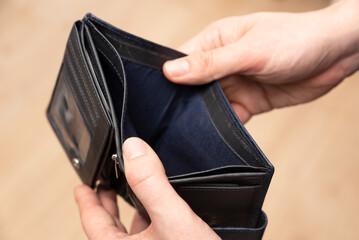 Empty wallet held in hands. Lack of money, poverty