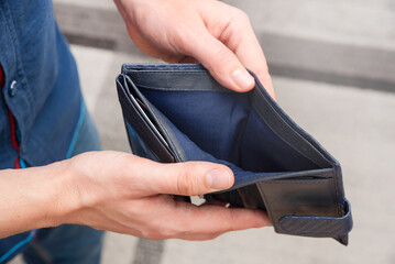 Empty wallet held in hands. Lack of money, poverty