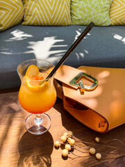 Vacation still life: a cocktail, woman's handbag, sunglasses, in the sunlight