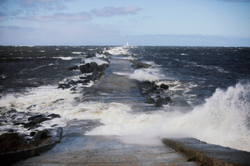 Storm waves crashing over a pier
