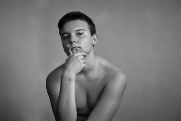 Portrait of a beautiful young man with a naked torso in the morning. The concept of a sporty lifestyle and a healthy diet.