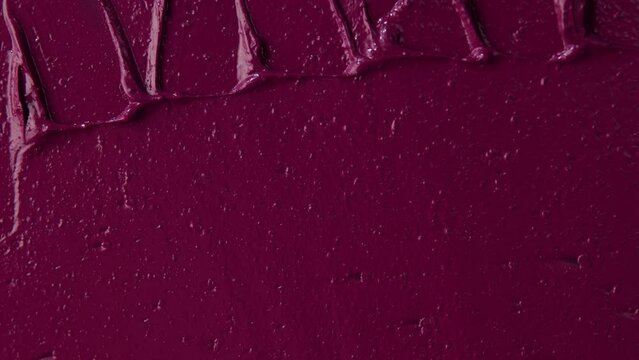 Texture of pink  lipstick close up. Spatula and pink paint. Advertising of decorative cosmetics. Advertising concept. Move with a spatula on a red texture. Pink color.