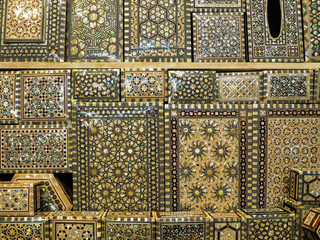 Handmade oriental pattern small jewellery chests souvenirs displayed on market in Marrakesh, closeup detail from above