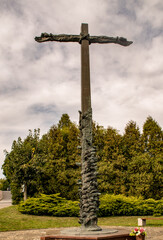 Old historical cross with hands next to the church.