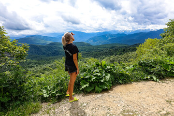 Naklejka premium A girl on the background of alpine meadows of the Lago-Naki plateau in Adygea. Russia. 2021.