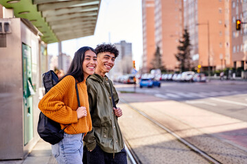teenage couple waiting at the train or tram stop. young students with a guitar and a ukulele in its...