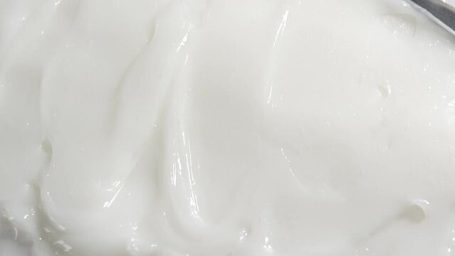 Smearing white cream with spatula. Moisturizing cosmetic for face, skin care product background.	