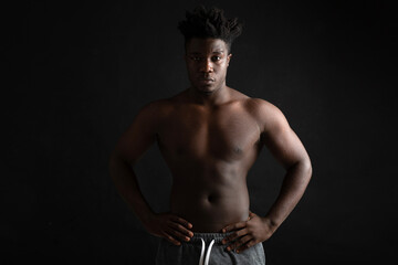 Fototapeta na wymiar athletic figure of an African man on a black background 