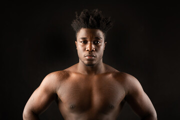 portrait of an african male with muscles on a black background 