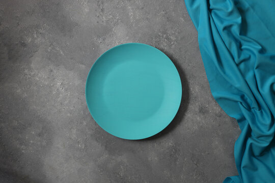 Empty blue slate plate on  stone table. Food background for menu, recipe. Table setting. Flatlay, top view. Mockup for restaurant dish	
