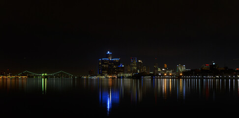Fototapeta na wymiar Night view of the city of Detroit skyscrapers with the reflections of the lights on the river 