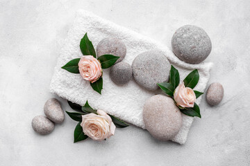 Spa treatment with stones and pink roses, top view