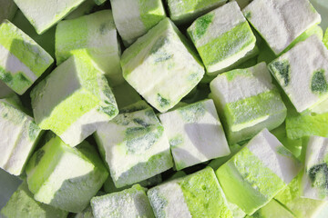 Close-up, marshmallow cubes, green kiwi fruit sweet dessert in sunlight