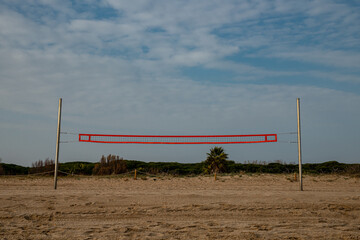 Beach volleyball court on a wild beach with green vegetation in the background awaits travelers...