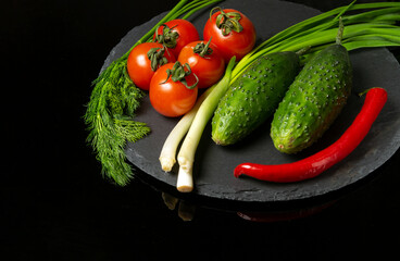 Big set for fresh vegetable salad. Red tomatoes and green young onions with cucumber on a vintage brown plate