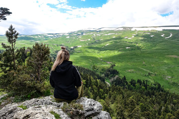 A girl on the background of alpine meadows of the Lago-Naki plateau in Adygea. Russia. 2021.