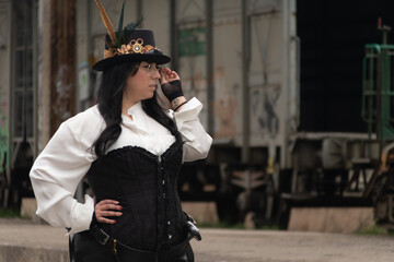 Thick woman dressed in steampunk style in a train car in an abandoned train station