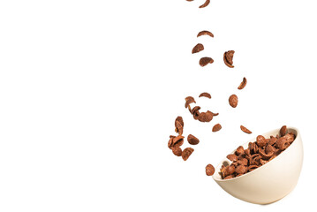Chocolate corn flakes falling to the white bowl isolated on white. Motion.