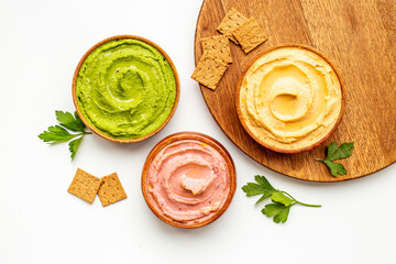 Green and purple hummus with spinach and beets in bowls, top view