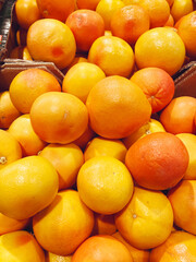 Many  orange grapefruit  stacked on a supermarket shelf