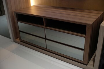 Dark brown wooden shelf furniture that is multi-functional, with a minimalist design in a hotel room.