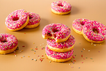 Group of pink frosted donuts with colorful sprinkles