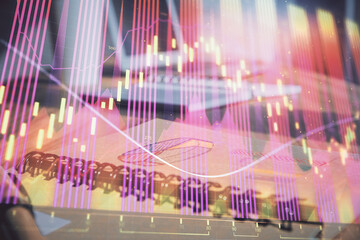 Double exposure of financial graph drawings and desk with open notebook background. Concept of forex market