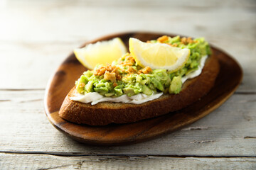 Homemade avocado toast with cream cheese and lemon