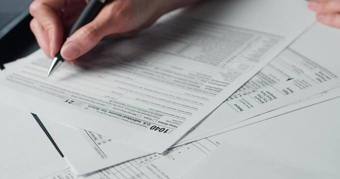 Woman Reads Irs Us Individual Income Tax Form 1040 in tax time. Closeup view. Individual Income Tax Return Form 1040