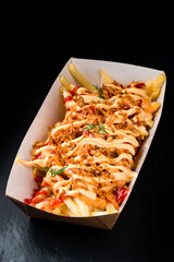 great box of fried chicken and bacon potatoes drizzled with cheddar cheese on top