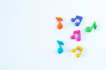 Colorful music notes shape isolated on white background. Copy space. Top view. The concept of happiness, joy, singing, and playing at school. A closeup.