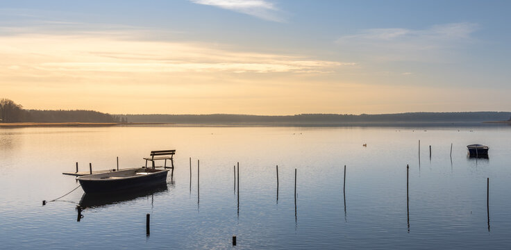 einsame Bank auf einem Steg am See