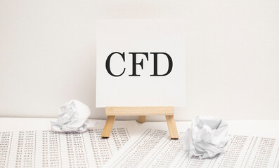 CFD - contract for difference on easel with office tools and paper.Top view. Business concept