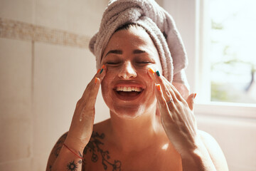 Beauty starts with being good to your skin. Shot of a young woman giving herself a facial at home.