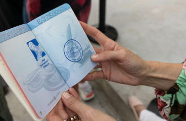 Woman's hands holding open yellow expo 2020 passport with stamps
