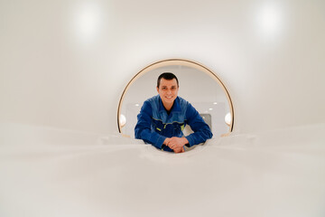 installer engineer of mri apparatus in scanner. blue uniform