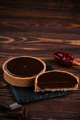 round tartlet in butter cream, baked tartlet dessert, chocolate tartlet with berry
