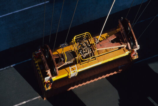 Looking from top of crane down at securred shipping container ready for raising up and loading