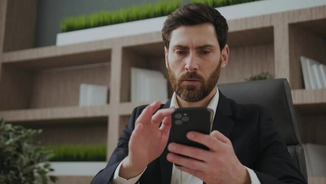 Confused executive is angry because mobile phone doesn't work properly. Annoyed and looking mad