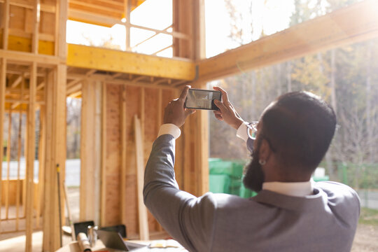 Male architect photographing house under construction