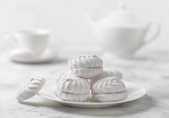 A stack of white marshmallows on a concrete background. The concept of minimalism in vegan sweets. Selective focus.