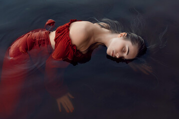 Fototapeta na wymiar Blonde girl bathes in a summer lake