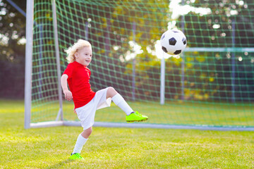 Kids play football. Child at soccer field.