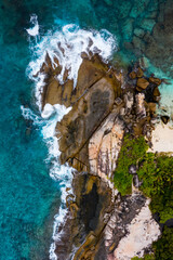 Fototapeta premium Aerial photo over Seychelles displaying the natural unspoilt beauty of the islands - from the crystal clear oceans to the lush green forests and granite boulders cascading on the white beaches. 
