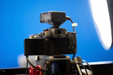 A modern professional high end mirrorless video camera on a tripod stand, bluescreen chroma key...
